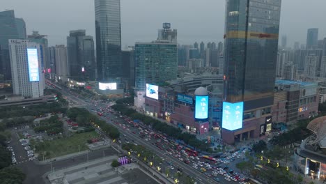 Downtown-street-of-Guangzhou-with-big-shopping-malls-and-dense-traffic-in-the-evening-after-pandemic-restrictions-lifted