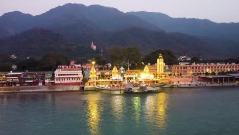holy-ganges-riverbank-filled-with-religious-temples-at-evening-aerial-shot-video-is-taken-at-parmarth-niketan-rishikesh-uttrakhand-india-on-Mar-15-2022