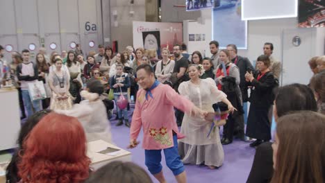Crowd-of-people-watching-Indonesian-cultural-traditional-dance,-inside-trade-show,-FITUR