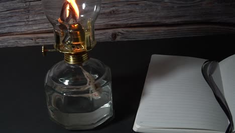 Old-hurricane-oil-lamp-with-an-open-book