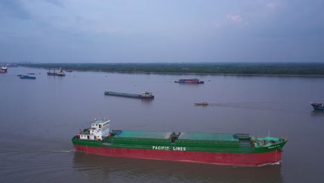 Aerial-view-of-cargo-ship-navigating-on-the-Saigon-River-in-Ho-Chi-Minh-City,-Vietnam