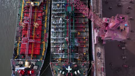 Shipyard-and-dry-dock-facility-Saigon-river-Vietnam-aerial-top-down-tracking-shot-over-large-tankers-being-repaired-and-empty-dry-dock