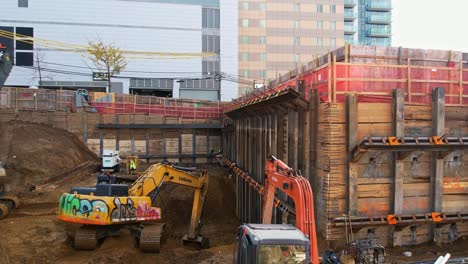 Panoramic-View-Of-Excavation-Site-For-High-Rise-Building-With-Excavators-Working-Surrounded-By-Construction-Site-Scenery