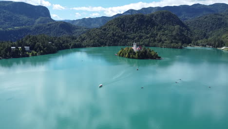 Drone-shot-of-Lake-Bled-in-Slovenia---drone-is-flying-towards-its-little-island-with-boats-cruising