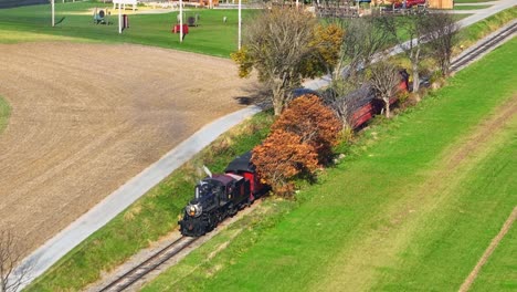 Aerial-Zoomed-in-View-of-an-Approaching-Steam-Passenger-Train-on-a-Single-Track-in-the-Countryside