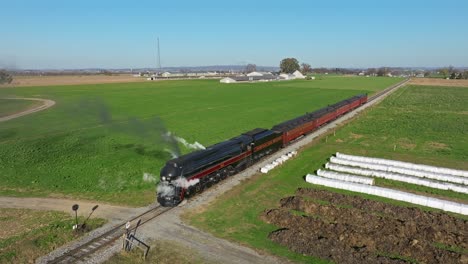 Drone-View-of-a-Steam-Passenger-Train-Blowing-Lots-of-Smoke-and-Steam-Standing-Still-on-a-Sunny-Fall-Day
