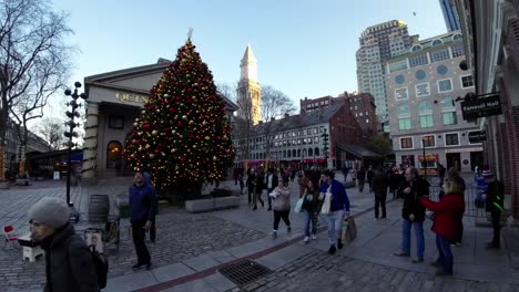 Pedestrians-walk-past-large-Christmas-tree-in-Boston,-Massachusetts-during-Christmas-time