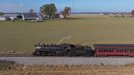 An-Aerial-Parallel-View-of-a-Steam-Passenger-Train-on-a-Single-Track-Thru-Farmlands-on-a-Sunny-Day
