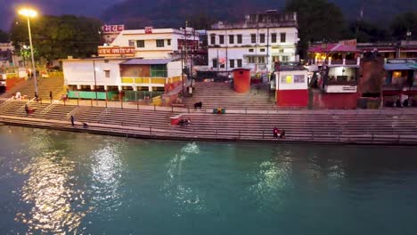 holy-ganges-riverbank-filled-with-religious-temples-at-evening-aerial-shot-video-is-taken-at-parmarth-niketan-rishikesh-uttrakhand-india-on-Mar-15-2022