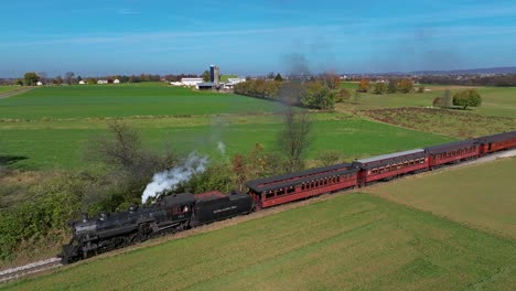 An-Aerial-View-of-a-Steam-Train-Blowing-Smoke-as-it-Travels-Thru-Country-Farmlands-on-a-Sunny-Fall-Day