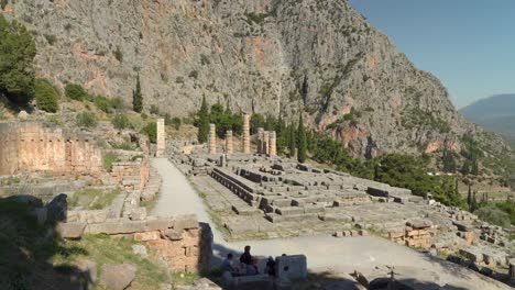 Weite-Aufnahme-Des-Ganzen-Tempels-Von-Apollo-In-Der-Archäologischen-Stätte-Von-Delphi-Mit-Bergen-Im-Hintergrund