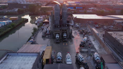 Aerial-View,-Concrete-Ready-Mix-Plant-Facility-and-Heavy-Mixer-Trucks-on-Loading-Station,-Drone-Shot-60fps
