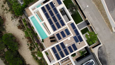Aufsteigende-Luftaufnahme-über-Sonnenkollektoren-Auf-Dem-Dach-Eines-Luxushauses-Auf-Einem-Hügel-In-Calp,-Spanien