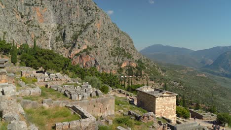 Panoramic-View-of-Treasury-of-Athenians-in-Delphi-Archaeological-Site-as-Visible-in-Background-on-Mountains
