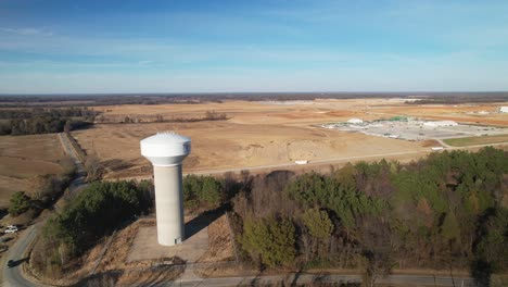 Aerial-approach-past-water-tower-revealing-sprawling-new-construction