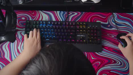 Top-shot-or-view-of-esport-gamer-playing-computer-game-with-RGB-keyboard-and-mouse