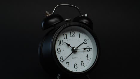Ticking-black-twin-bell-Alarm-clock,-zoom-dolly-in-shot,-time-passing-concept
