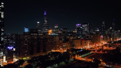 Aerial-view-of-illuminated-buildings-and-the-Grant-park,-night-in-Chicago,-USA---panoramic,-drone-shot