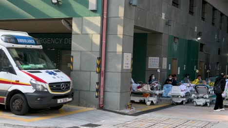 A-panning-shot-shows-an-ambulance-stationed-at-the-hospital-entrance-as-patients-with-Covid-19-symptoms-lie-in-the-bed-outside-an-overcrowded-hospital-while-the-medical-system-collapses