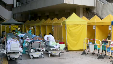 Chinesische-Patienten-Mit-Covid-19-symptomen-Liegen-Im-Bett-Auf-Der-Straße-Vor-Einem-überfüllten-Krankenhaus,-Während-Das-Medizinische-System-Mit-Krankenhauseinweisungen-Zusammenbricht