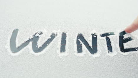 Invierno-Escrito-En-Nieve-En-El-Parabrisas-Del-Coche,-Temporada-De-Clima-Frío