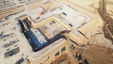Aerial-pan-of-excavated-dirt,-equipment,-and-new-construction