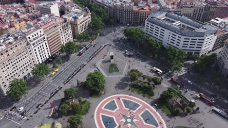 Concurrida-Plaza-De-Cataluña-Con-El-Tráfico-De-Automóviles-Y-Personas-Que-Se-Muestran-En-El-Fondo-Y-Revelan-Lentamente-La-Ciudad-De-Barcelona
