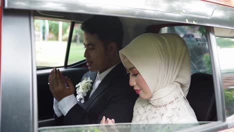 Ein-Junges-Indonesisches-Paar,-Das-Im-Auto-Zu-Gott-Um-Schutz-Betet,-Bevor-Es-Aus-Dem-Auto-Steigt,-Um-Seine-Hochzeitszeremonie-Durchzuführen