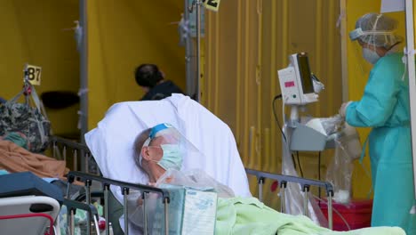 Un-Paciente-Enfermo-Con-Síntomas-De-Covid-19-Descansa-En-La-Cama-En-La-Calle-Frente-A-Un-Hospital-Abarrotado-Mientras-El-Sistema-Médico-Colapsa-Con-Las-Hospitalizaciones