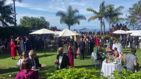 Panning-view-of-happy-people-enjoying-a-beautiful-outdoor-wedding-at-an-estate-overlooking-the-sea-in-Tenerife,-Spain