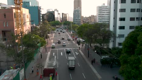 Aerial-shot-over-a-San-Isidro,-Lima,-Peru-avenue-close-to-the-ground-and-between-buildings
