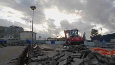 A-construction-site-in-Amsterdam,-a-beautiful-sky-opens-above-a-kubota-excavator