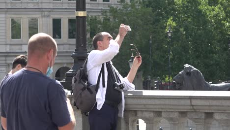 Confused-tourists-take-pictures-of-the-new-modern-art-installation-in-Trafalgar-Square,-London,-UK