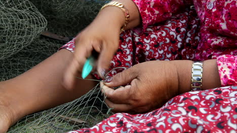 Woman-repairing-a-fishing-net-in-Cambodia