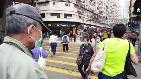 Corona-Pandemic,-People-crossing-the-street-in-Downtown-Hong-Kong-wearing-protective-face-masks-during-Corona-Virus-outbreak
