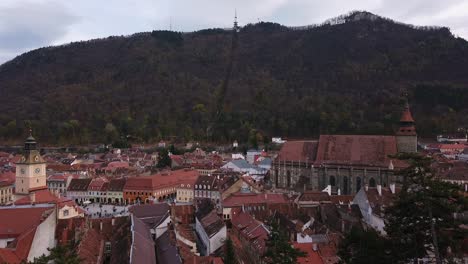 Full-shot,-Scenic-view-of-Roofs-and-Houses-in-Brasov,-Romania,-Forest-range-in-the-background