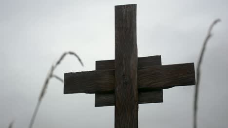 Wooden-Cross-in-the-Rain-on-a-Cloudy-Day-Close-Up-Perspective-Shot