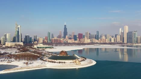 Aerial-view-towards-the-sunlit-Adler-Planetarium,-winter-evening-in-Chicago,-USA