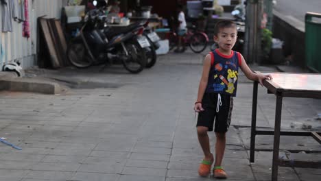 Kausales-Asiatisches-Männliches-Kind,-Das-Auf-Den-Straßen-Von-Bangkok-Spielt