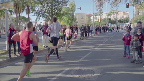 Spectators-cheering-up-runners-at-Malaga's-Marathon,-slow-motion,-Spain