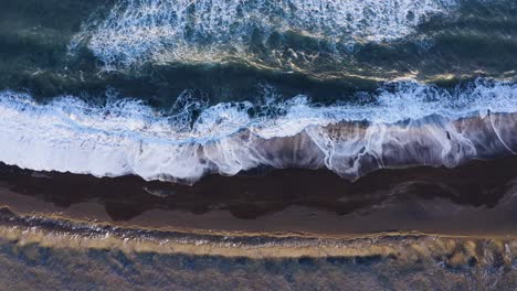 Aerial-Drone-View-Of-Waves-Crashing-In-To-The-Shoreline-Of-South-Coast-Beach---static-shot
