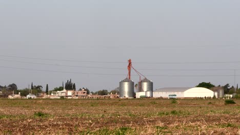 Silos-and-a-warehouse-on-the-background-of-a-stubble-covered-field