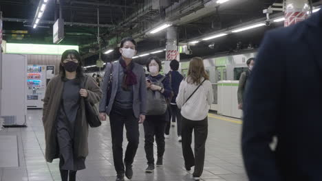 Viajeros-Japoneses-Con-Máscara-Caminando-En-La-Plataforma-De-La-Estación-De-Metro-Durante-La-Pandemia-Del-Virus-De-La-Corona-En-Tokio,-Japón