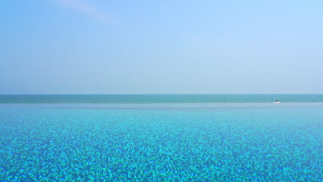 Shades-of-blue-on-tropical-caribbean-destination,-infinity-pool,-skyline-and-sea-static-full-frame