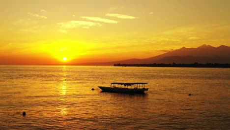 Golden-sunset-over-the-ocean-with-small-fishing-boats-and-mountains