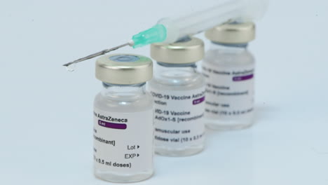 Spritze-Mit-Nadel-über-Astrazeneca-Covid-19-Impfstoffampullen
