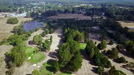 Aerial-view-over-the-the-Trentham-golf-course-with-the-township-in-the-background,-Victoria,-Australia