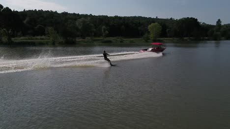 Speed-boat-pulling-water-ski-surfer-across-lake-water-fast-speeding-spray-closeup-towards-camera