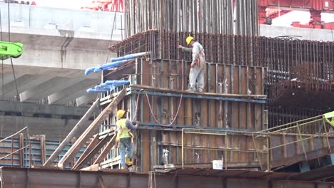 Trabajadores-De-La-Construcción-Que-Trabajan-En-Altura-Instalando-Barras-De-Refuerzo-Y-Formando-Trabajos-En-El-Sitio-De-Construcción