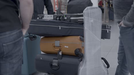 Four-musicians-stand-around-luggage-and-guitar-cases-at-the-airport